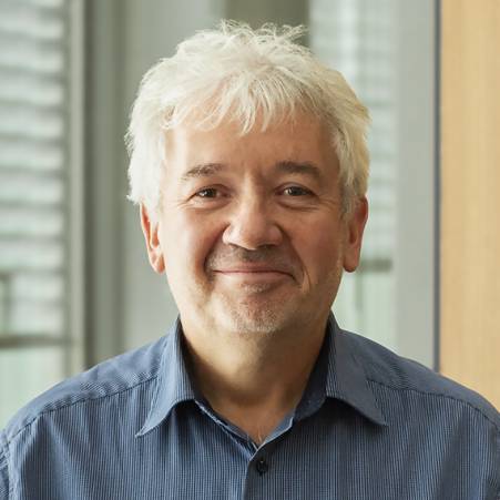 Knut Polkehn hat kurzes, weißes Haar. Er trägt ein hellblaues Hemd und lächelt.