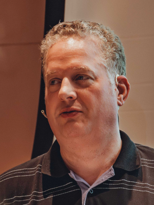 Andreas Hinderks hat kurzes helglraues Haar und trägt ein gestreiftes Hemd.