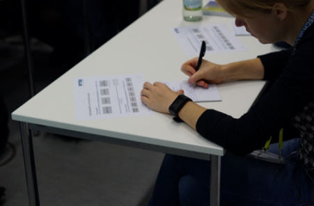 Teilnehmer am Schreibtisch arbeitend